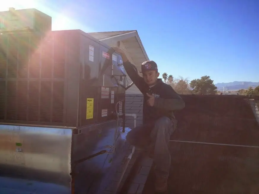 HVAC technician performing Air Duct Repair on a rooftop unit in Gresham